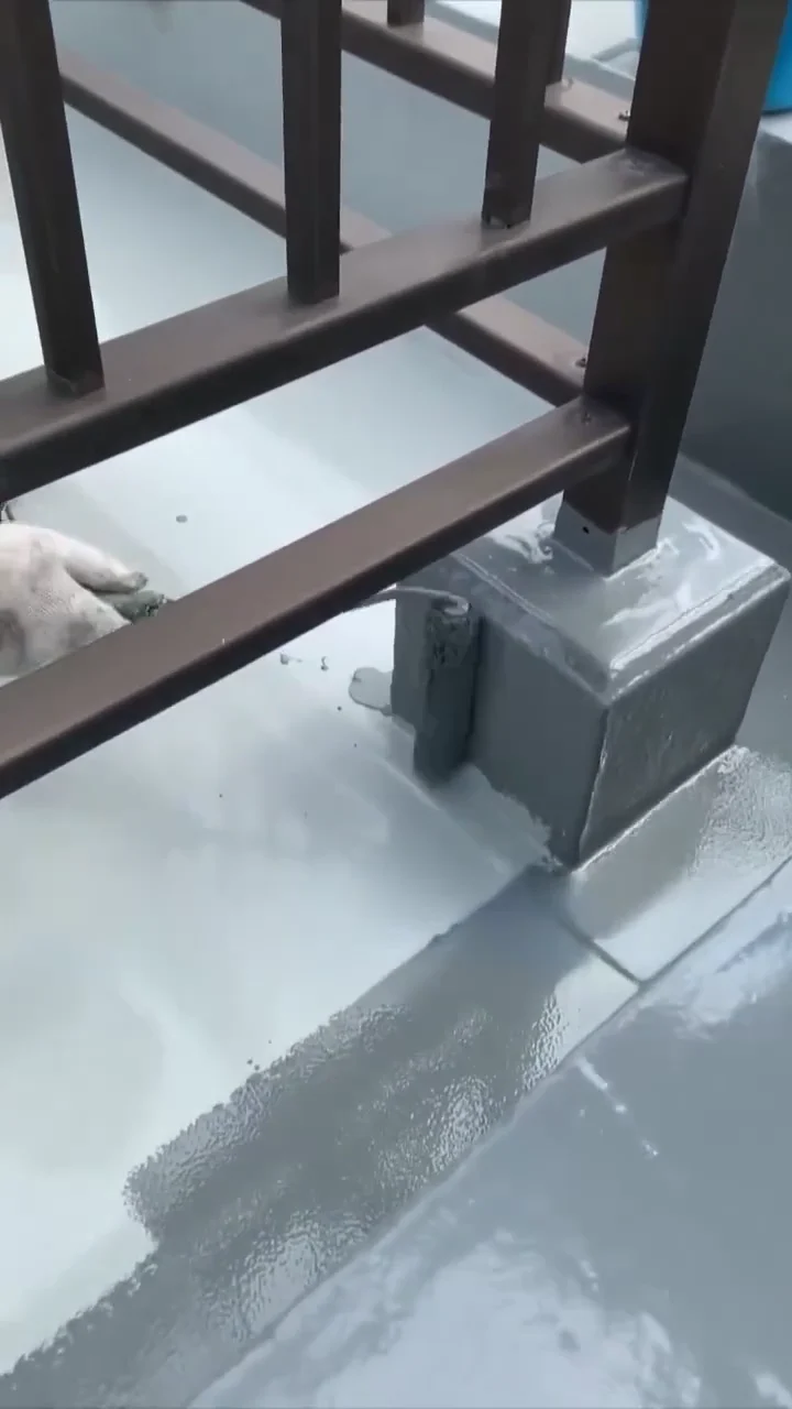 Close-up of grey coating around a balcony railing base and the adjacent floor