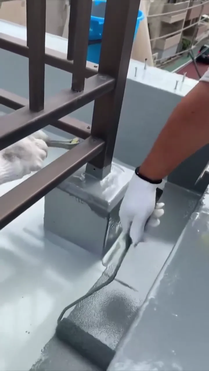 施工人员在阳台栏杆立柱基座周围涂刷灰色防水涂层 施工人员在阳台栏杆立柱基座周围涂刷灰色防水涂层